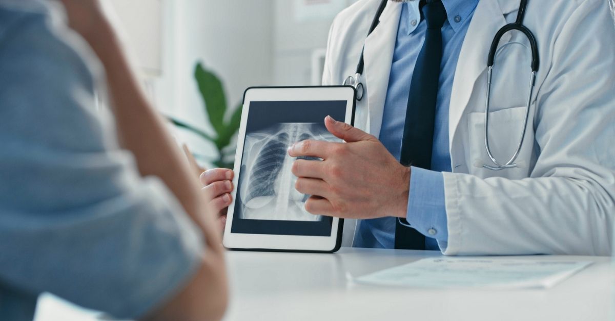 Doctor showing lung x-ray to patient.